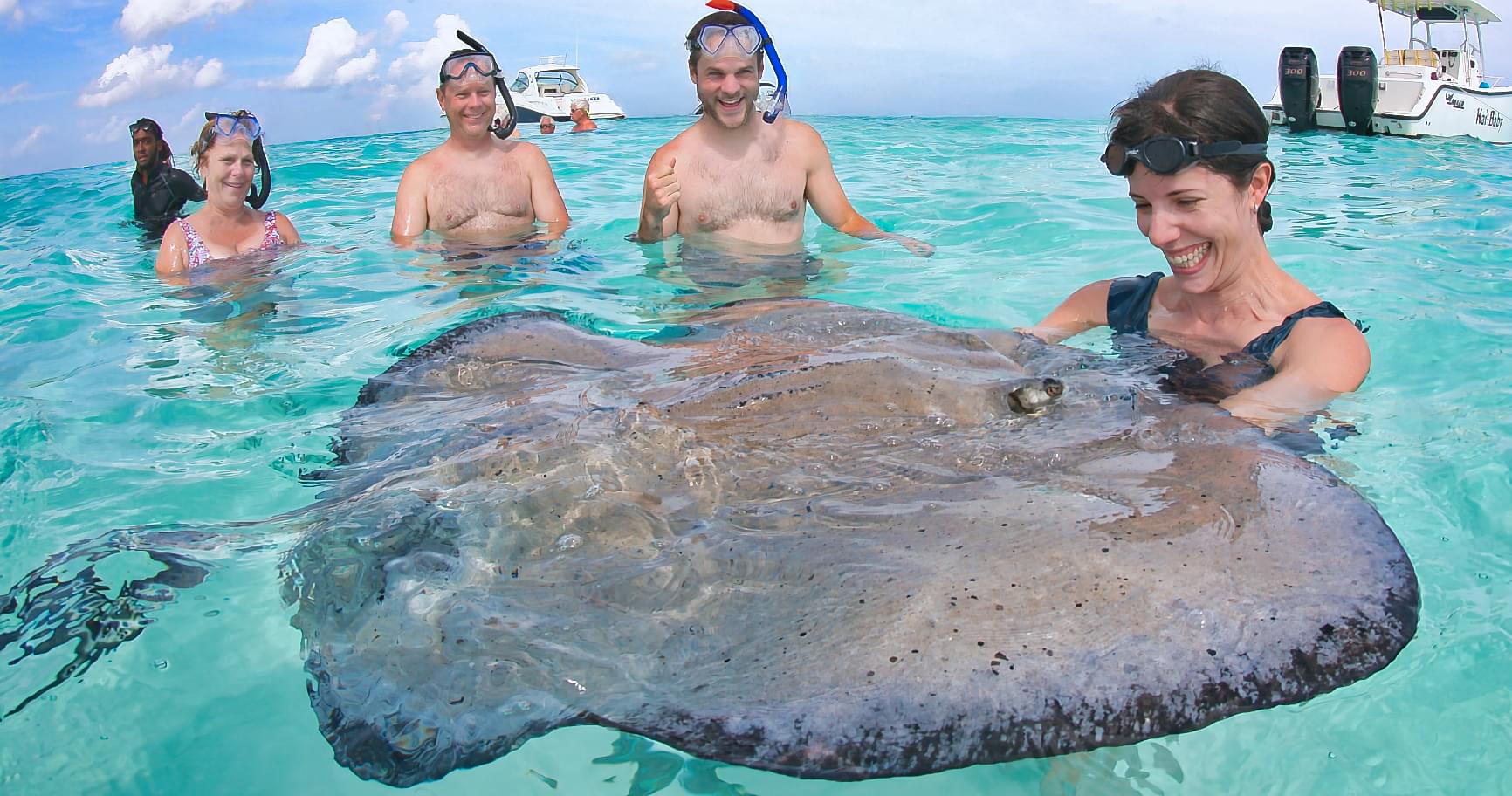 Guests interacting with a stingray at Stingray City as part of pre-wedding activities