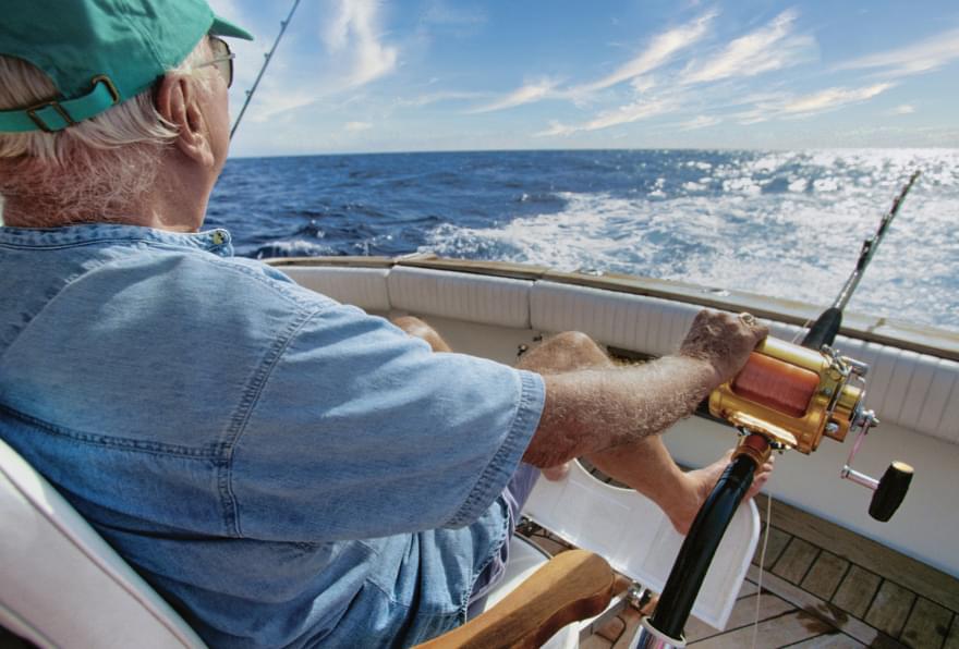 Fisherman deep-sea fishing near Grand Cayman, benefiting from steady Cayman Islands water temperature