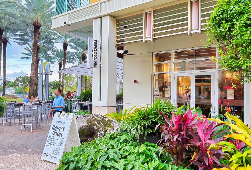 Outdoor seating at Brooklyn, a family-friendly spot in Camana Bay, featuring American comfort food.