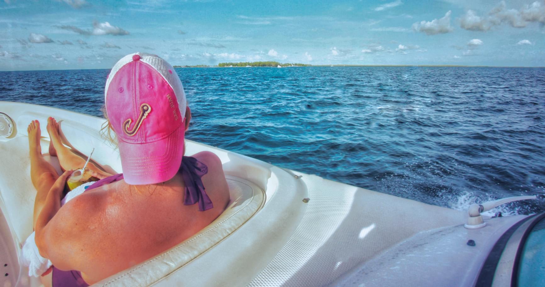 A traveler relaxing on a boat in calm turquoise waters, enjoying Cayman’s tranquil vibe