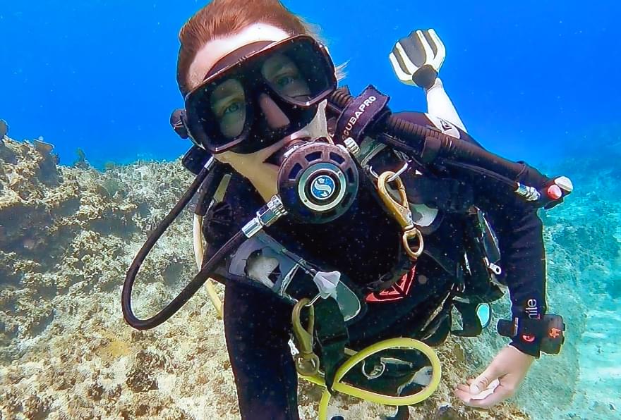 Diver exploring vibrant coral reefs in Cayman Island attractions, enjoying marine life.