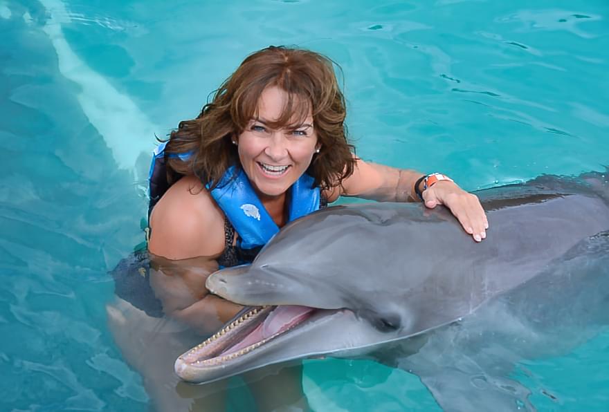 Woman swimming with a dolphin, Dolphin in Grand Cayman