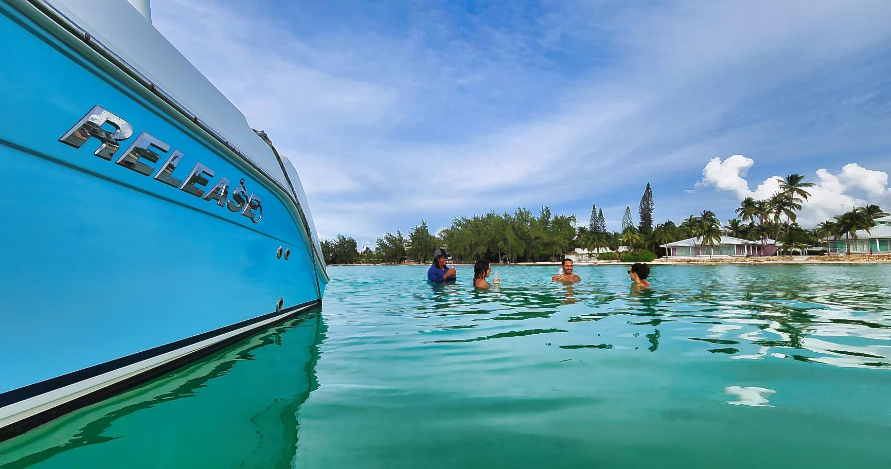 Crystal-clear waters near a docked boat at Rum Point, inviting adventure seekers