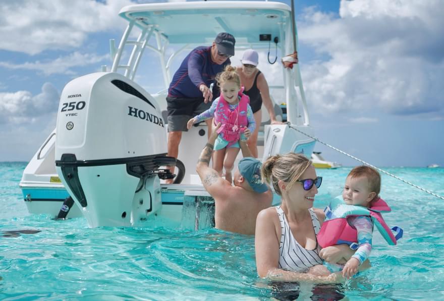 Family boarding a boat for a grand Cayman Island Stingray city tour, preparing for a memorable day
