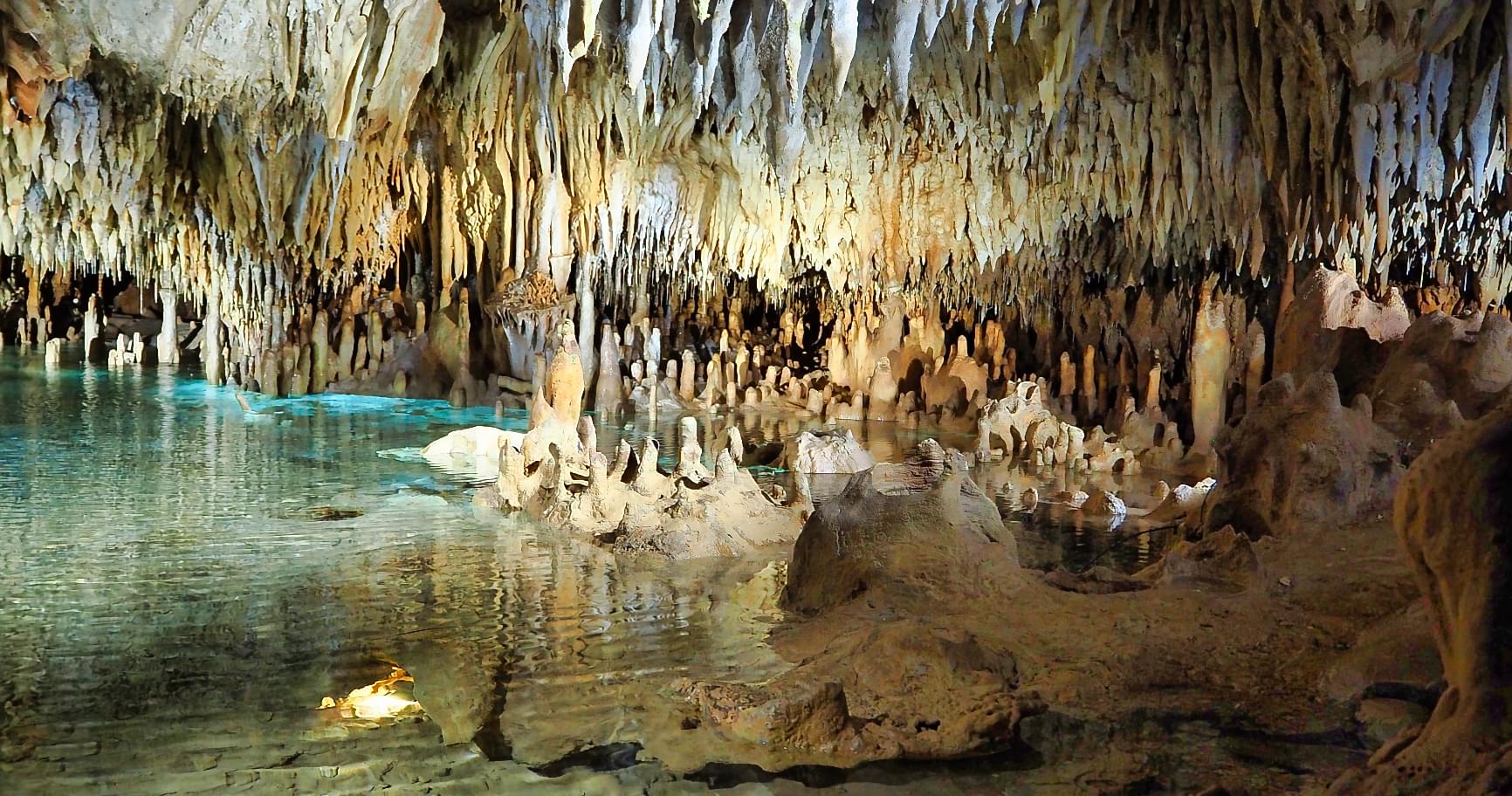 Underground lake reflecting formations, creating a serene and picturesque scene