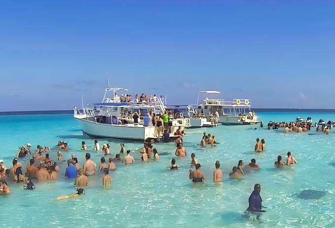 crowd and tour boats at grand cayman stingray city excursion