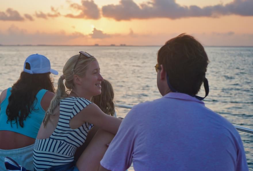 people watching sunset from a boat before a grand cayman bioluminescence tour