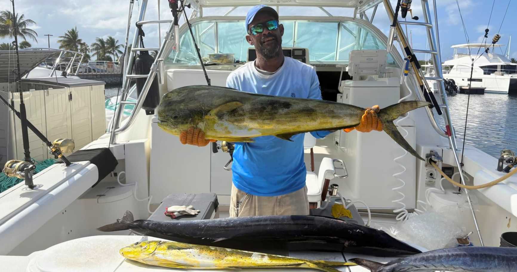 crew member holding mahi mahi on a grand cayman fishing charter