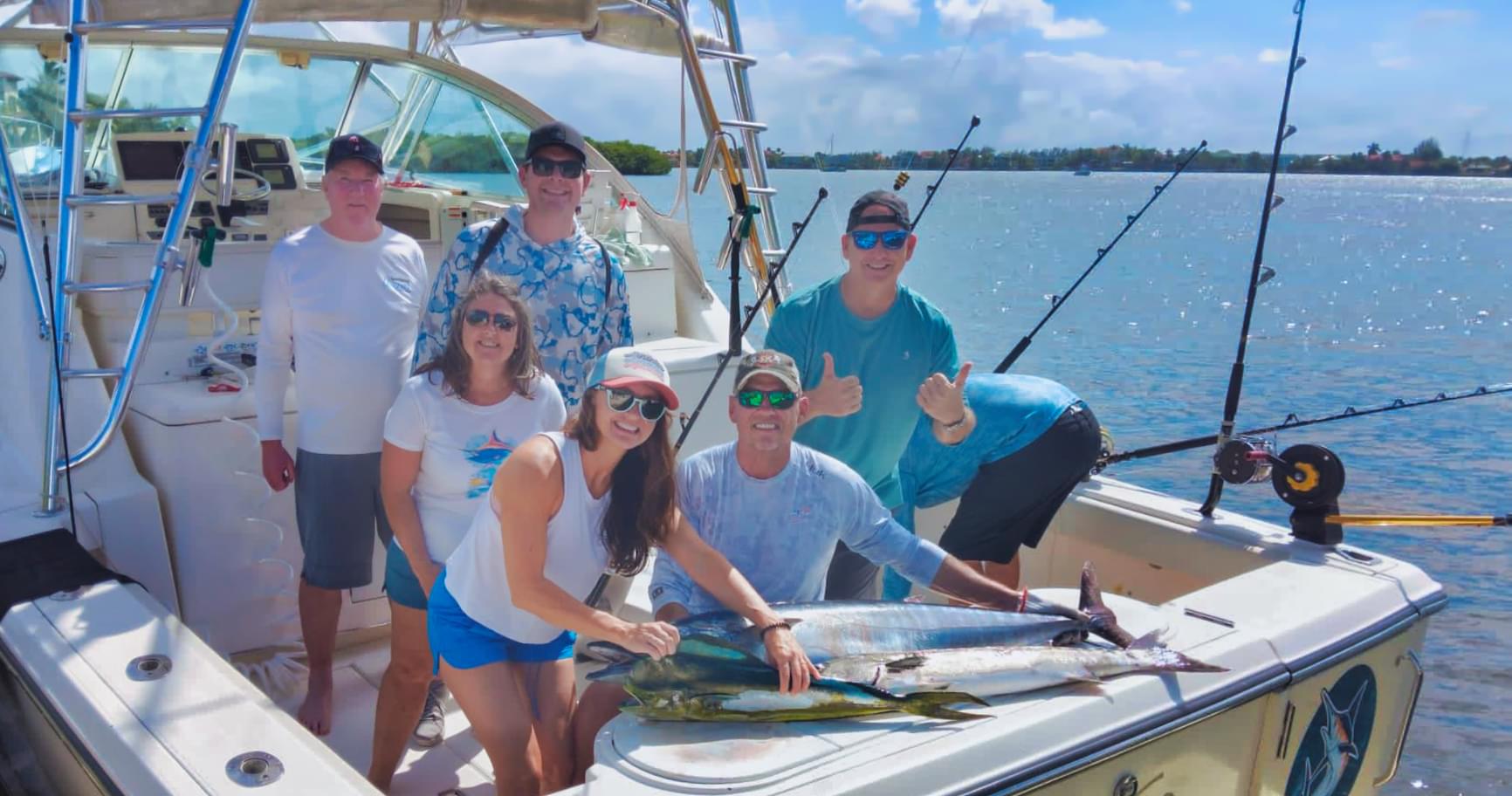 group of anglers aboard boat with fresh catch after fishing charters in grand cayman