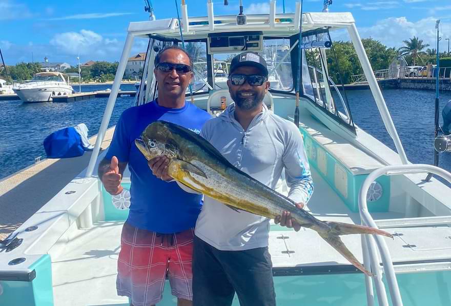 two anglers holding mahi mahi caught offshore in clear water