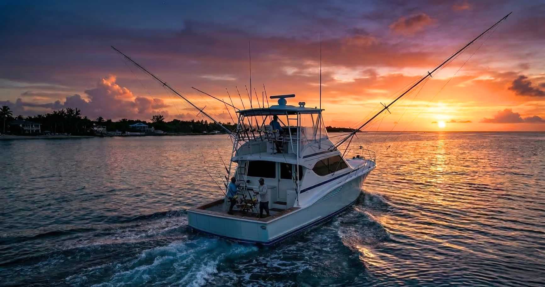 sportfishing boat at sunset representing best time to fish in cayman islands