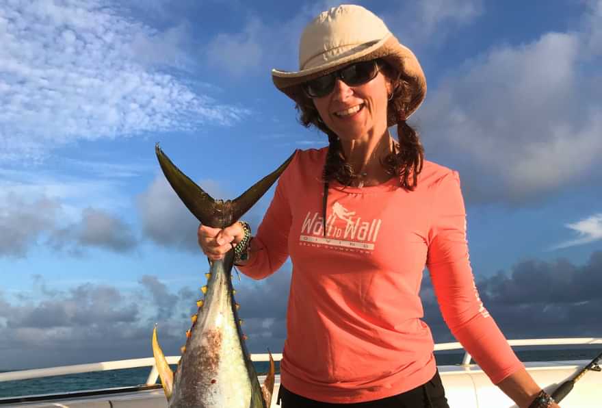 woman holding tuna on boat for grand cayman fishing charter prices